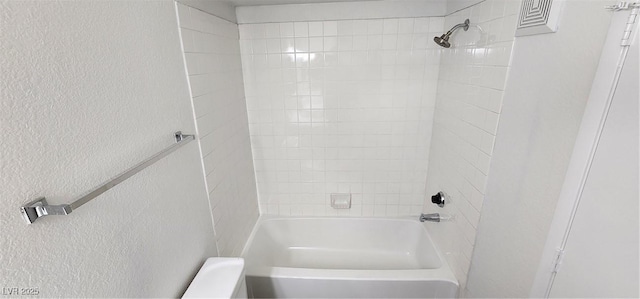 bathroom featuring tiled shower / bath