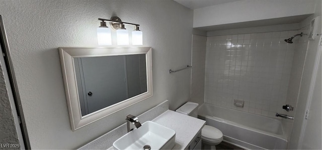 full bathroom with vanity, tiled shower / bath combo, and toilet