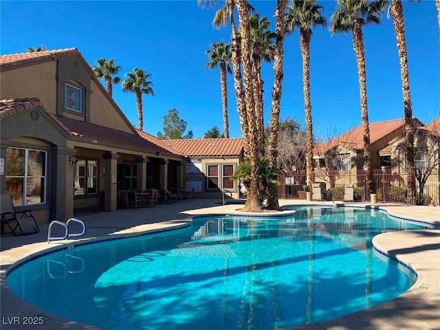 pool featuring fence and a patio