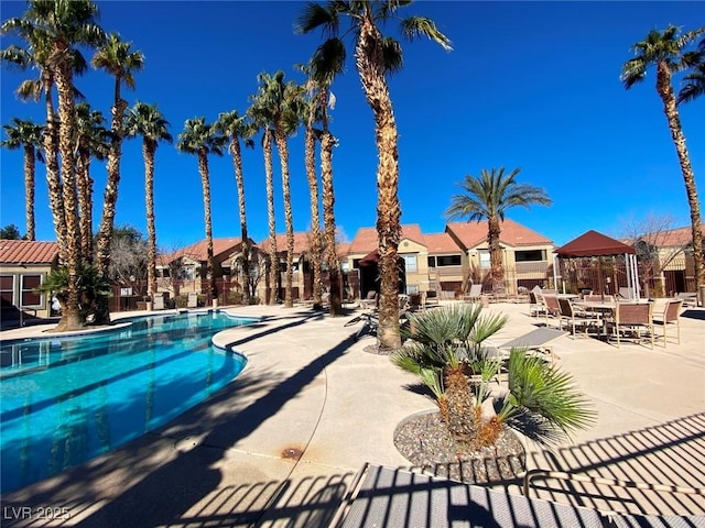 pool with a residential view and a patio