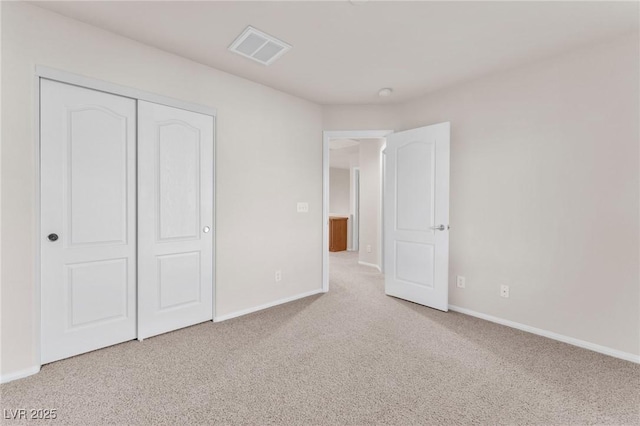 unfurnished bedroom featuring a closet and light carpet