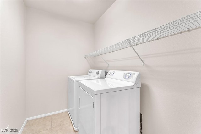 clothes washing area featuring washing machine and dryer and light tile patterned flooring