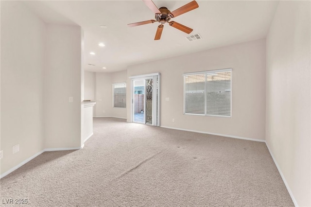 spare room featuring ceiling fan and light colored carpet