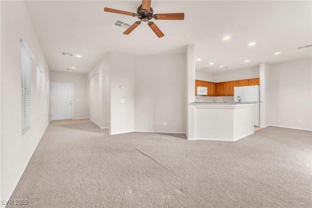 unfurnished living room featuring ceiling fan and light colored carpet