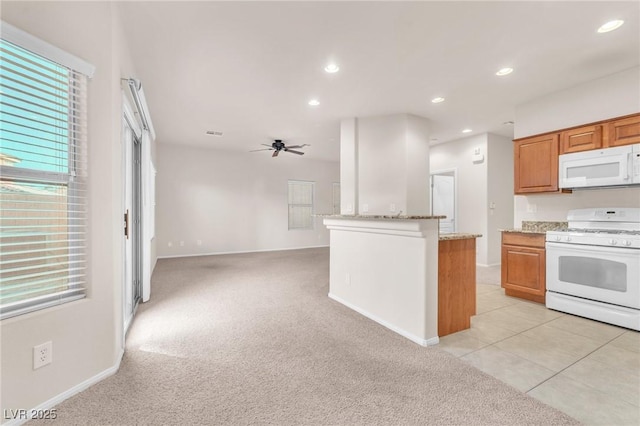 kitchen with ceiling fan, light colored carpet, white appliances, and light stone countertops