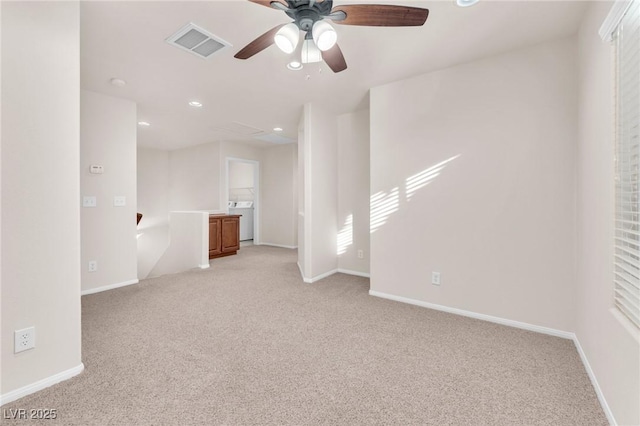 carpeted empty room with ceiling fan and washer / clothes dryer