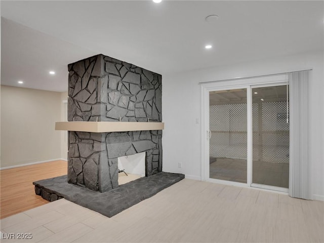 living room featuring light hardwood / wood-style flooring and a stone fireplace