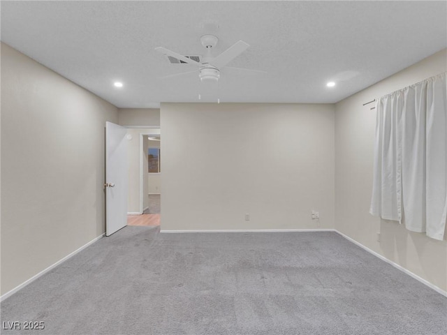 empty room featuring ceiling fan and light colored carpet