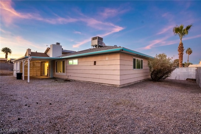 back house at dusk featuring central air condition unit