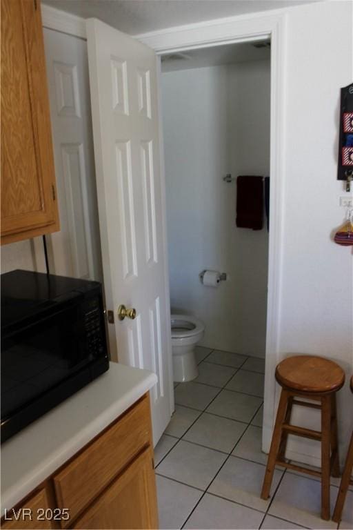 bathroom featuring toilet and tile patterned flooring