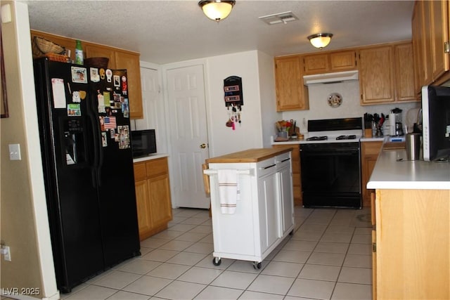 kitchen with black appliances, a center island, and light tile patterned flooring