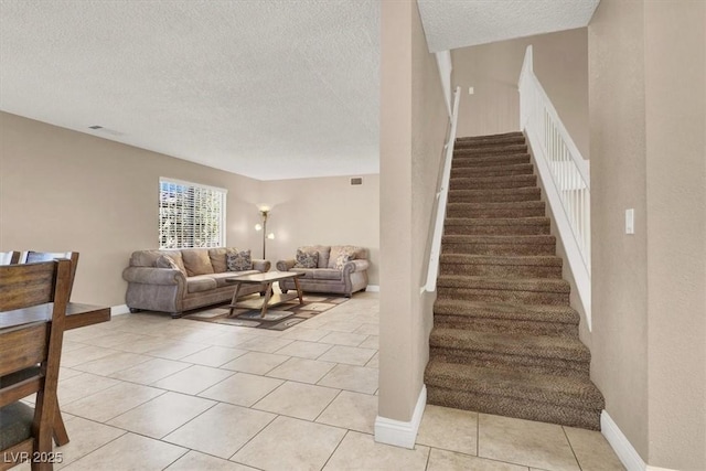 stairs with a textured ceiling and tile patterned floors