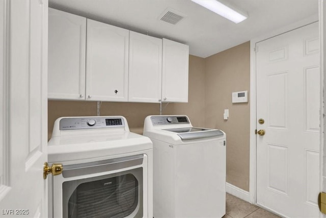 laundry room with light tile patterned flooring, separate washer and dryer, and cabinets