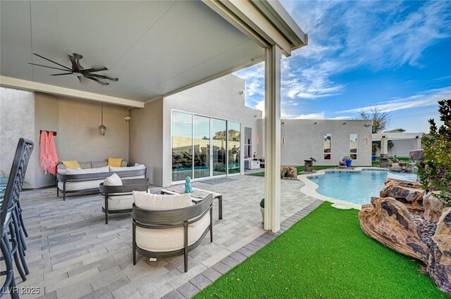 view of pool with ceiling fan, a patio area, and an outdoor living space