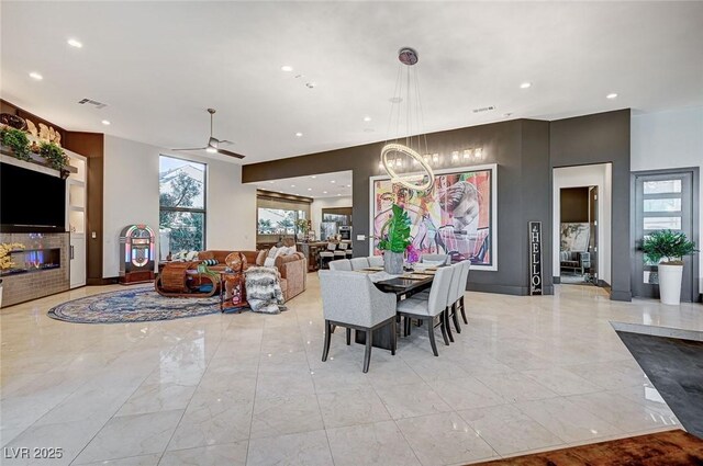 dining space featuring ceiling fan with notable chandelier