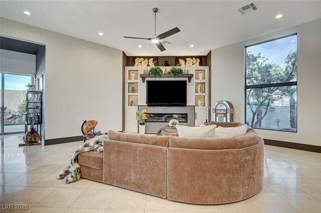 living room featuring ceiling fan, light tile patterned floors, and built in features