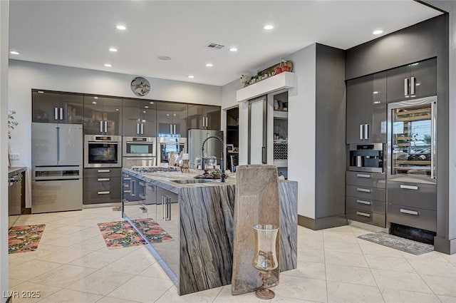 kitchen with stainless steel appliances, light tile patterned flooring, and sink