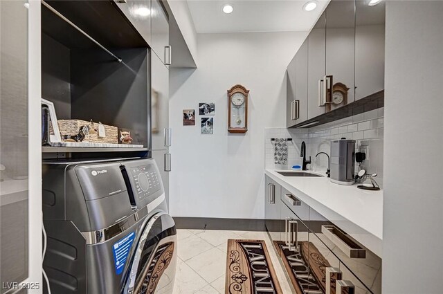 kitchen with sink, washer / clothes dryer, decorative backsplash, and gray cabinets