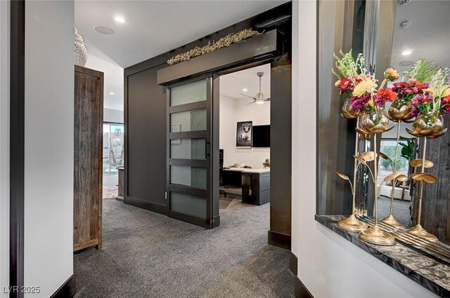 hallway featuring vaulted ceiling and dark carpet