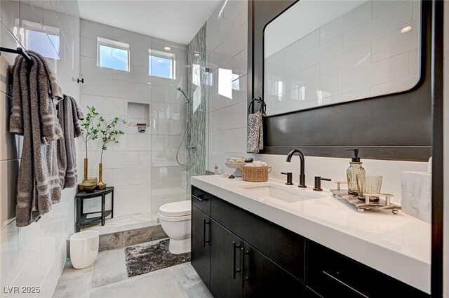 bathroom with vanity, tiled shower, and toilet