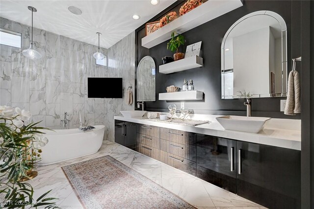 bathroom with tile walls, a bathing tub, and vanity