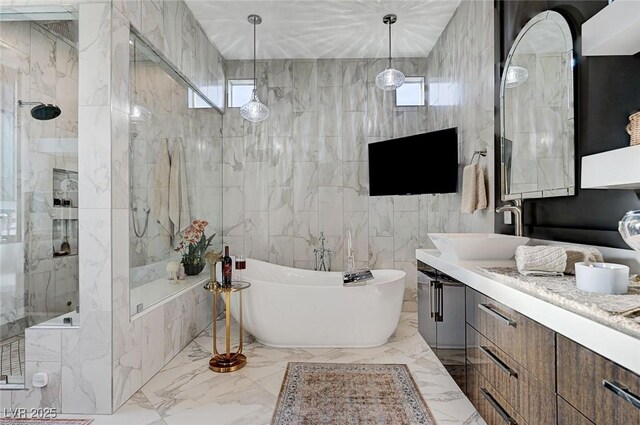 bathroom with tile walls, separate shower and tub, vanity, and plenty of natural light