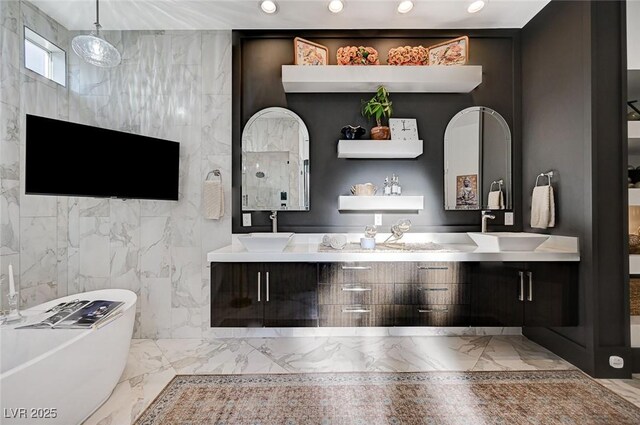 bathroom with tile walls, a tub, and vanity