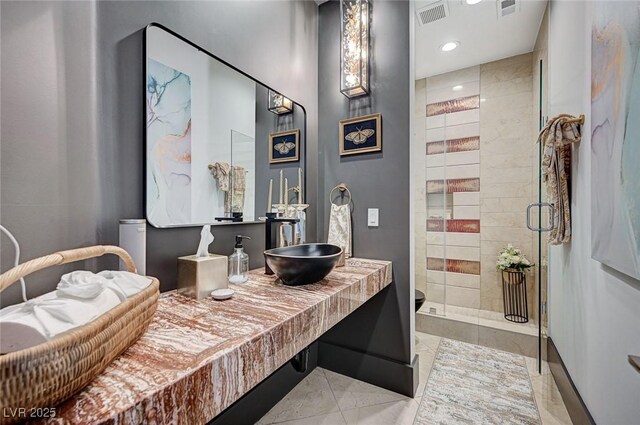 bathroom with tile patterned floors, a shower with shower door, and sink