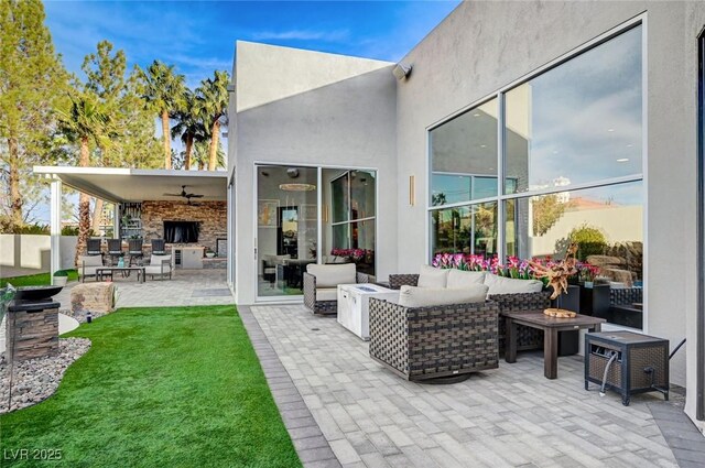 back of house featuring an outdoor living space with a fire pit, a patio area, and ceiling fan