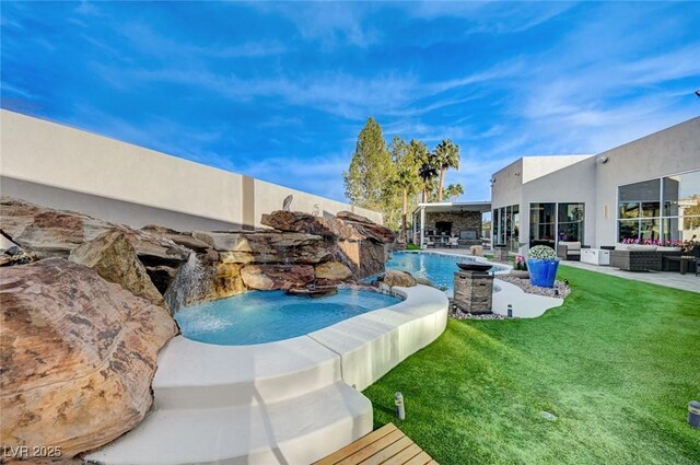 view of swimming pool featuring a lawn, pool water feature, a jacuzzi, and a patio