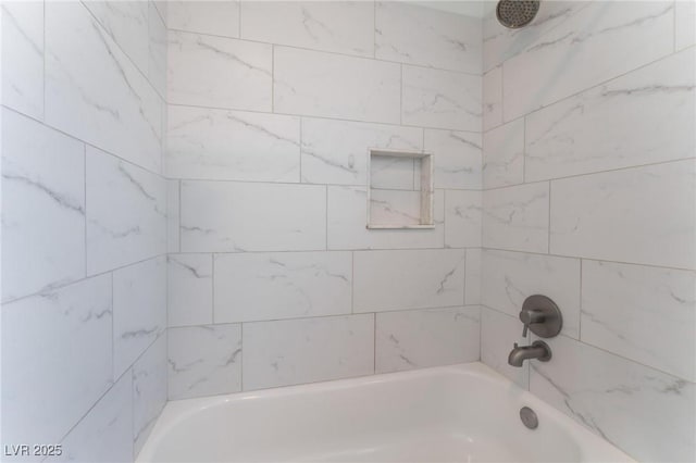 bathroom featuring tiled shower / bath