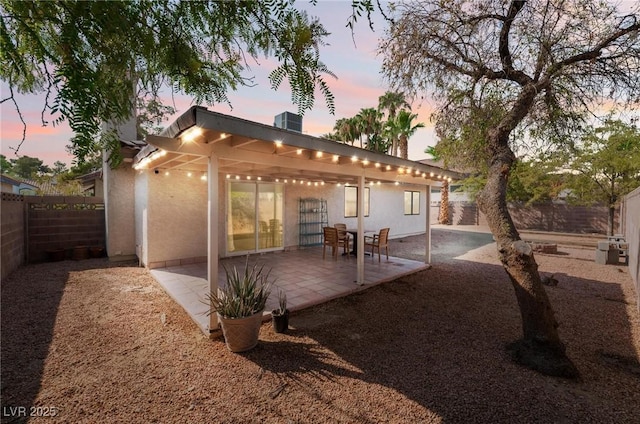 back house at dusk with a patio