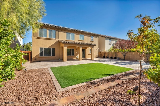 rear view of property with a patio and a yard