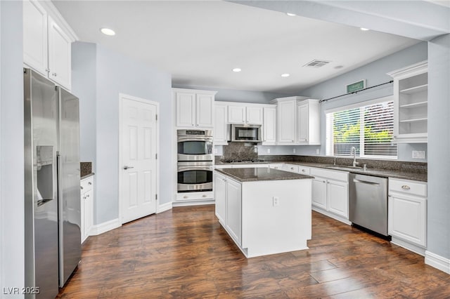 kitchen featuring dark hardwood / wood-style floors, a center island, white cabinets, appliances with stainless steel finishes, and sink