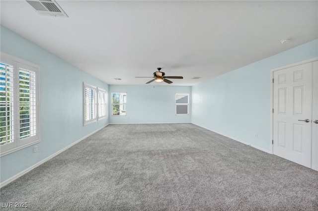 carpeted spare room featuring ceiling fan