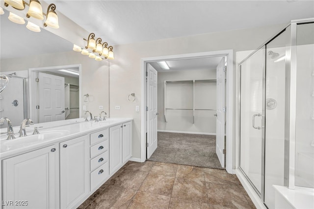 bathroom featuring a shower with door and vanity