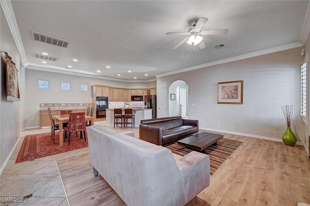 living room with ornamental molding and ceiling fan