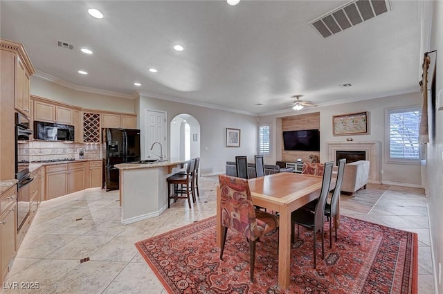 dining space with a healthy amount of sunlight, ceiling fan, ornamental molding, and light tile patterned flooring