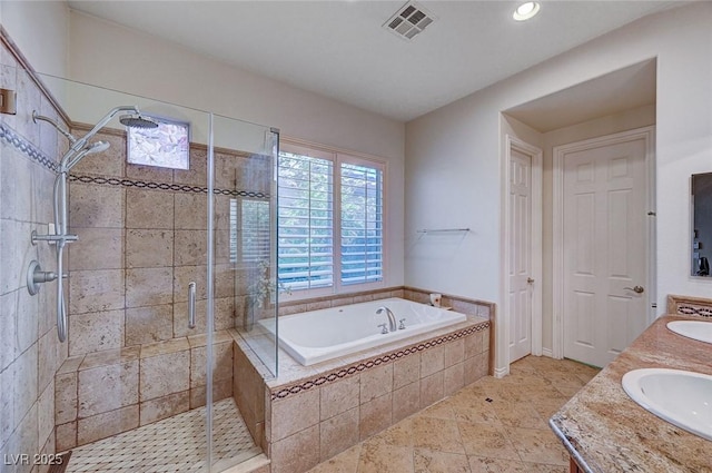 bathroom with vanity and shower with separate bathtub