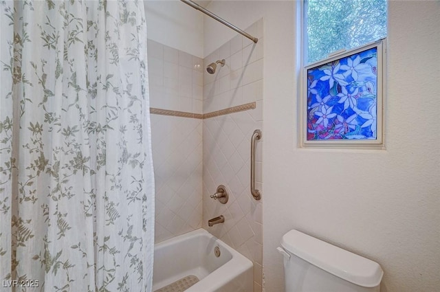 bathroom featuring toilet and tiled shower / bath combo