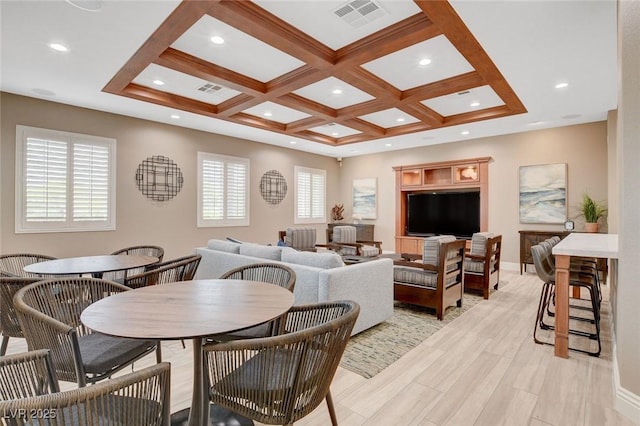 dining area featuring beamed ceiling, light hardwood / wood-style flooring, coffered ceiling, and plenty of natural light