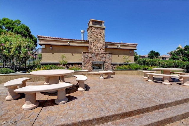 view of patio featuring an outdoor stone fireplace