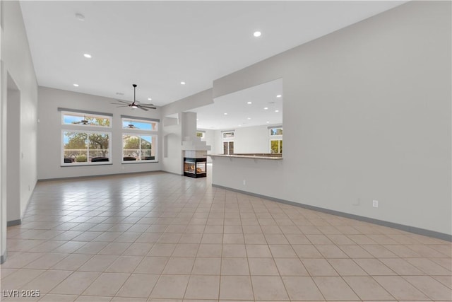 unfurnished living room with ceiling fan and light tile patterned flooring