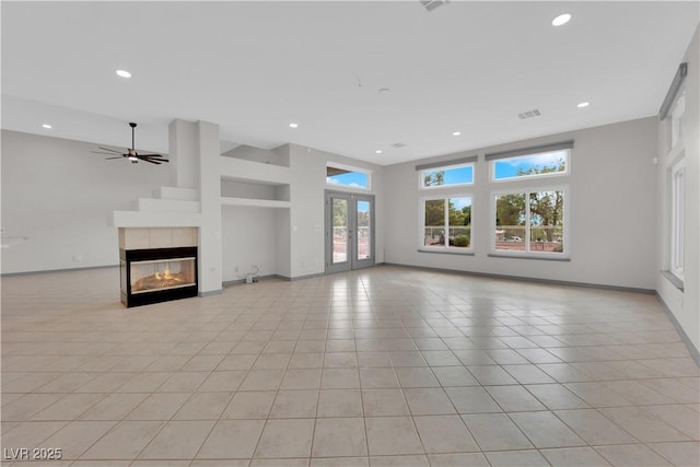 unfurnished living room featuring light tile patterned floors, ceiling fan, french doors, a fireplace, and built in features