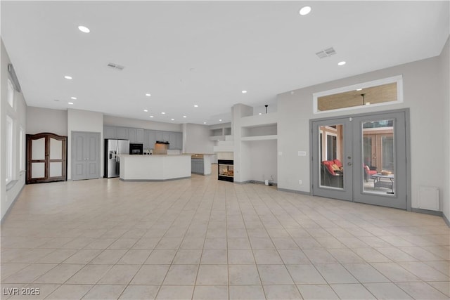 unfurnished living room with french doors and light tile patterned floors