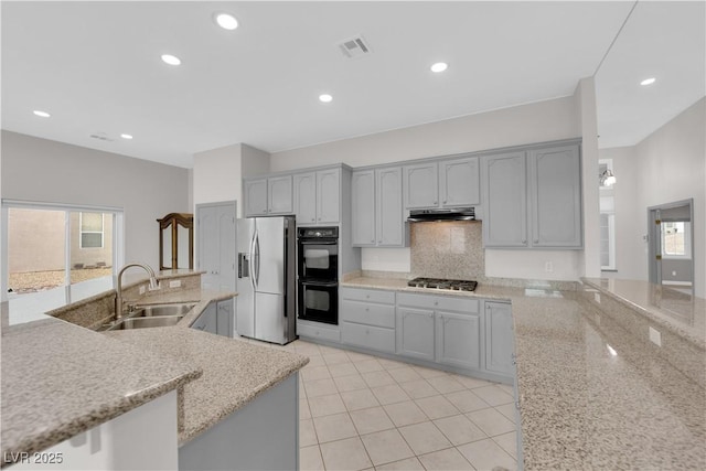 kitchen featuring gray cabinetry, stainless steel appliances, plenty of natural light, and decorative backsplash