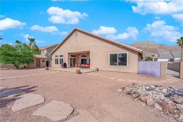 rear view of house with a patio and a mountain view