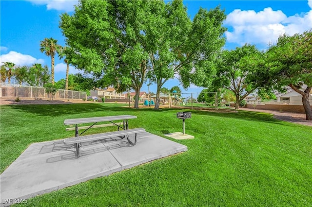 view of property's community with a playground and a yard