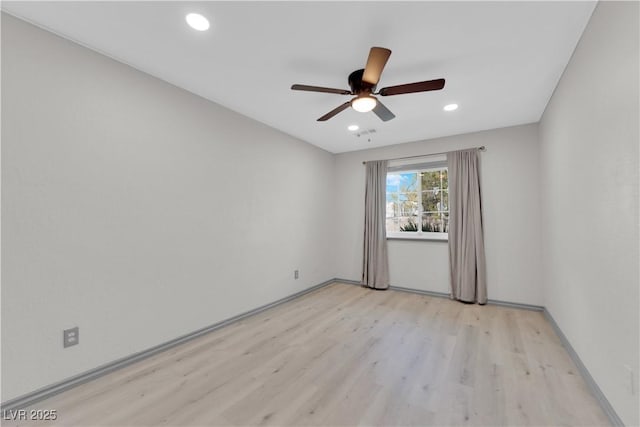 empty room with ceiling fan and light hardwood / wood-style flooring