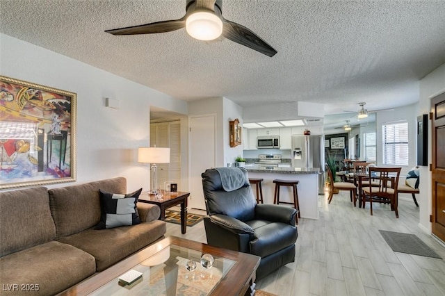 living room with a textured ceiling and light hardwood / wood-style floors